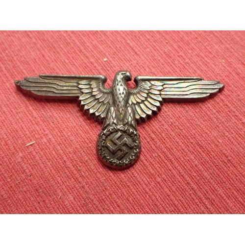 61 - WW2 German SS visor cap eagle

Turned to a dark grey patina. Both fixing pins remain to the back. Wi... 
