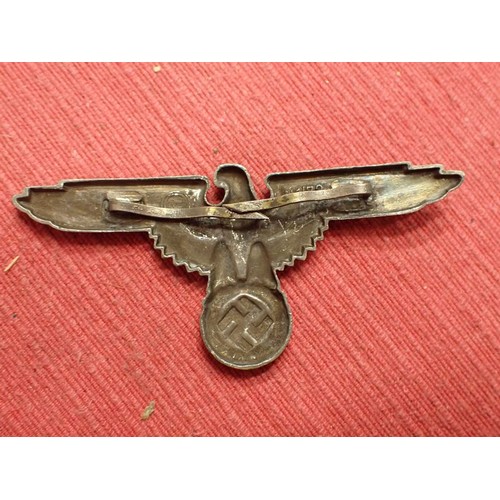61 - WW2 German SS visor cap eagle

Turned to a dark grey patina. Both fixing pins remain to the back. Wi... 