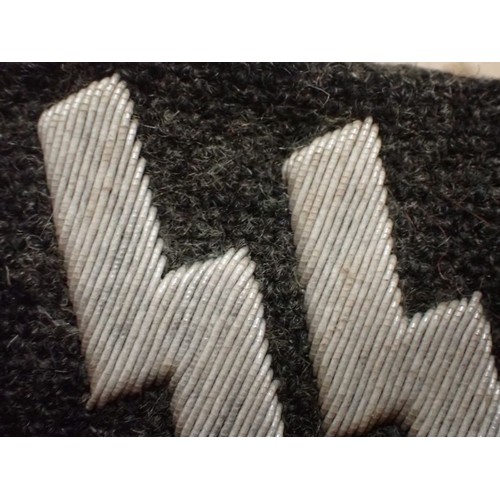 19 - WW2 German runic Waffen-SS collar tab

Tabin in well-worn condition. Some staining. Light frosted pa... 