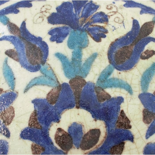 153 - An Antique Iznik style tile, decorated with flower heads in turquoise and blues, 8.5ins x 9ins