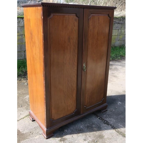 24 - A Heals mahogany wardrobe, with two panelled doors, opening to reveal hanging space, raised on ogee ... 