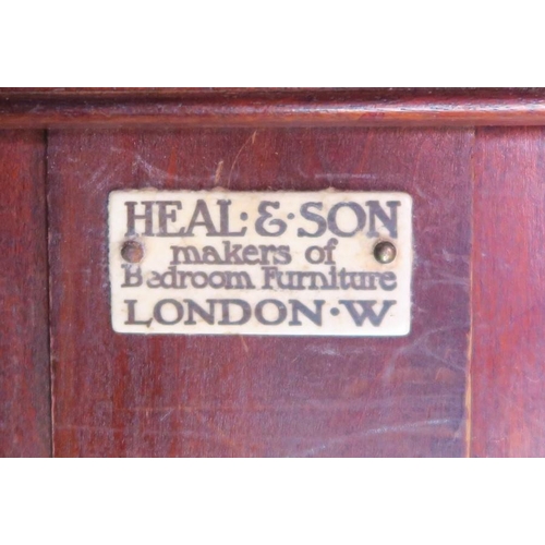 24 - A Heals mahogany wardrobe, with two panelled doors, opening to reveal hanging space, raised on ogee ... 