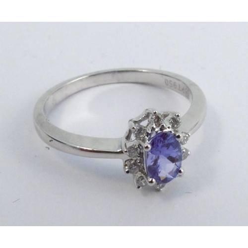 260 - A tanzanite and diamond platinum ring, the oval cut enclosed by ten brilliant cuts totalling approxi... 