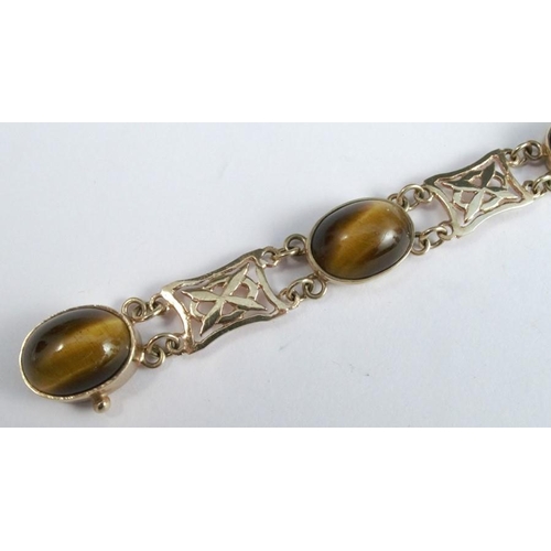 276 - A 9 carat gold tiger eye bracelet, the five cabochons with pierced panels between, 19cm long, 16g gr... 