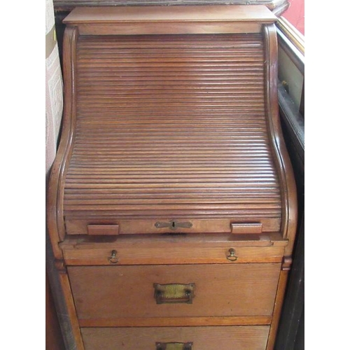 79 - An oak roll top desk, with serpentine roll top, over a pull out writing surface and two drawers