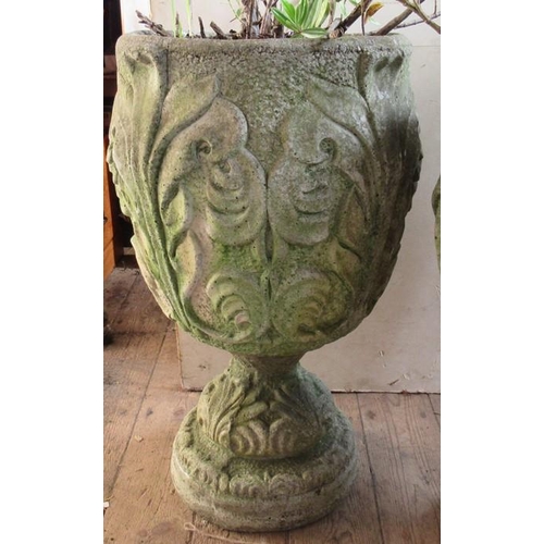 88 - A pair of concrete garden urns, decorated with leaves, on a pedestal foot, height 25.5ins