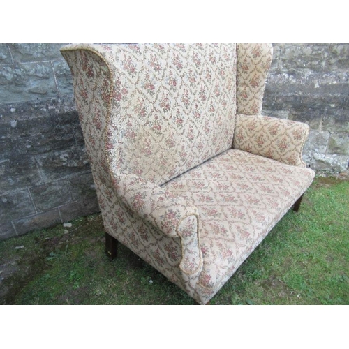 6 - A high backed wing back two seater settee, the floral upholstery, width 53ins x height 47ins