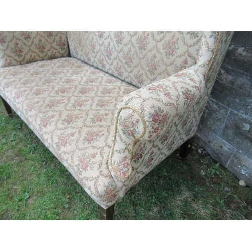 6 - A high backed wing back two seater settee, the floral upholstery, width 53ins x height 47ins