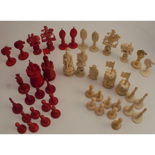 153 - A collection of carved bone chess pieces, some carved with puzzle balls, natural or stained red, in ... 