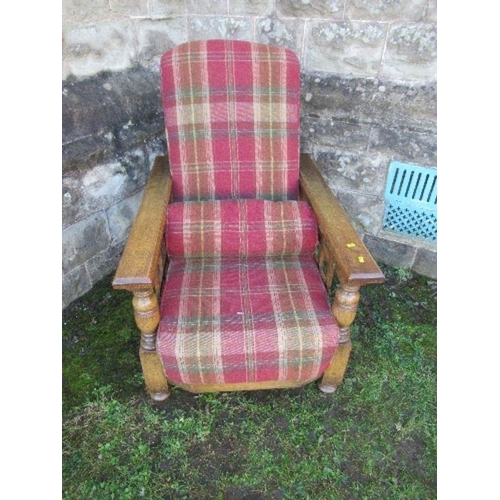 63 - An oak framed steamer chair, with tartan upholstery