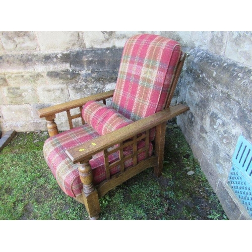 63 - An oak framed steamer chair, with tartan upholstery