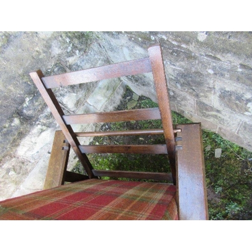 63 - An oak framed steamer chair, with tartan upholstery