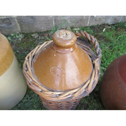 65 - A large collection of stoneware bottles, some with wicker mounts and a jug