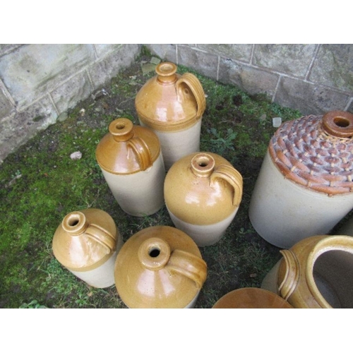 65 - A large collection of stoneware bottles, some with wicker mounts and a jug