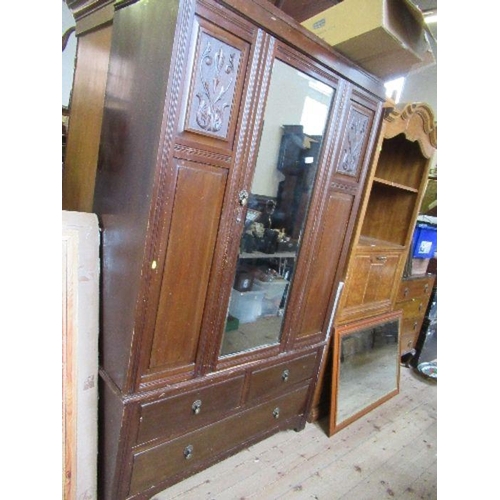 73 - An Edwardian mirror door wardrobe, with carved decoration and drawers to the base, width 49ins, heig... 