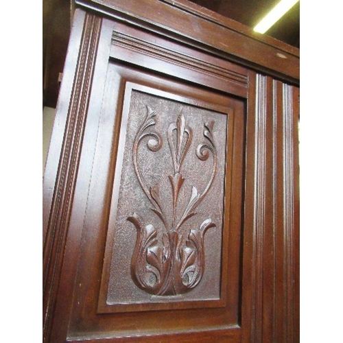 73 - An Edwardian mirror door wardrobe, with carved decoration and drawers to the base, width 49ins, heig... 