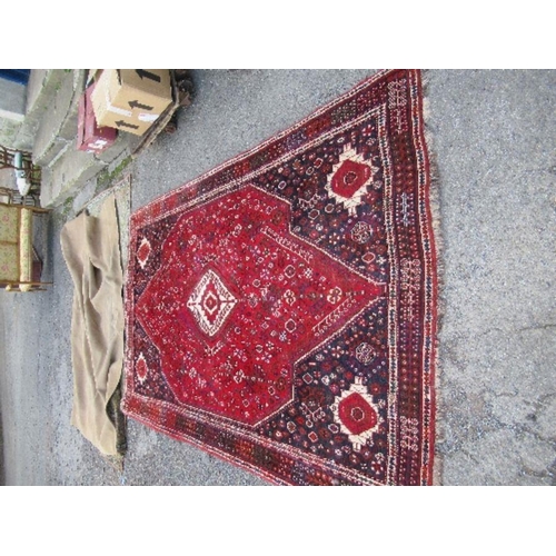 77 - An Eastern design red ground rug, 67ins x 114ins