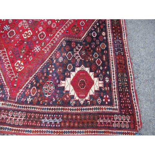 77 - An Eastern design red ground rug, 67ins x 114ins