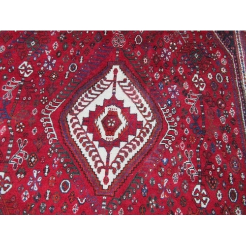 77 - An Eastern design red ground rug, 67ins x 114ins