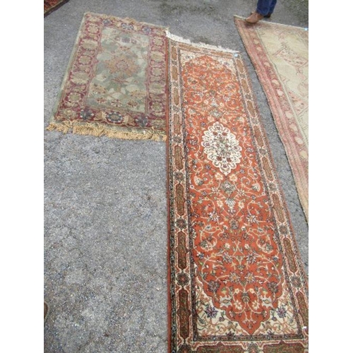 80 - An Eastern style runner, with orange ground field, 30ins x 100ins, together with another rug, 31ins ... 