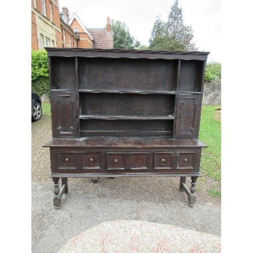 85 - An oak dresser, with close boarded rack back, fitted with cupboards, the base with three drawers, wi... 