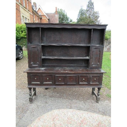 85 - An oak dresser, with close boarded rack back, fitted with cupboards, the base with three drawers, wi... 