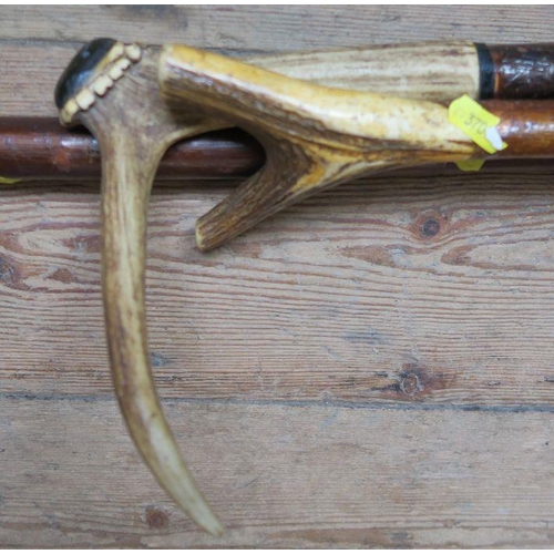 191 - Two antler horn handled walking sticks, together with another stick