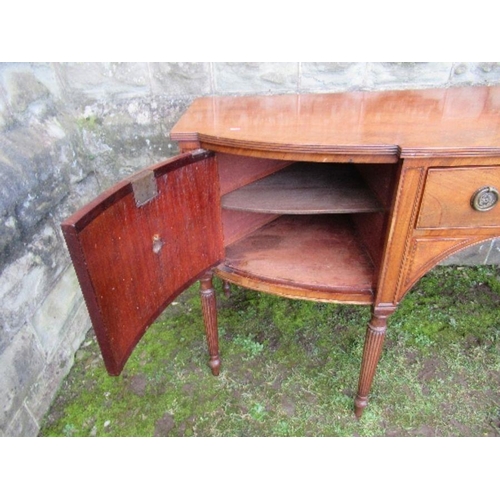 53 - A Regency mahogany bow front sideboard, fitted with a central drawer flanked by cupboard doors, open... 