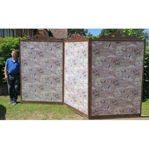 14 - A large oak framed three fold screen with decoration to the top, each panel 90ins x 55.5ins