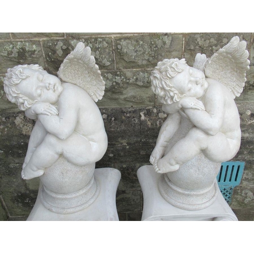 76 - A pair of modern plastic cherubs, sleeping on urns on pedestals, height 53ins