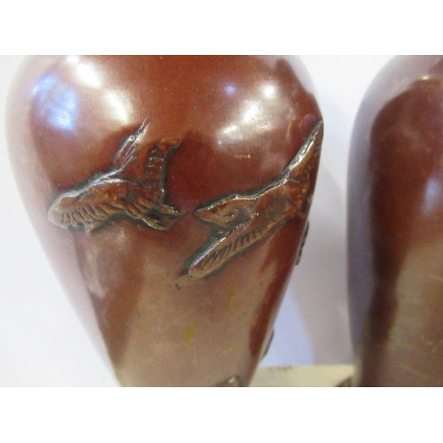 177 - A pair of Eastern metal vases, of baluster form, decorated with birds, height 9ins