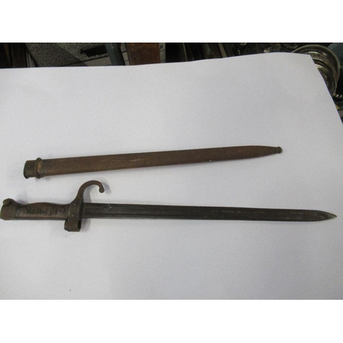 196 - A bayonet with metal scabbard, fullered blade and stud work to the wooden handle