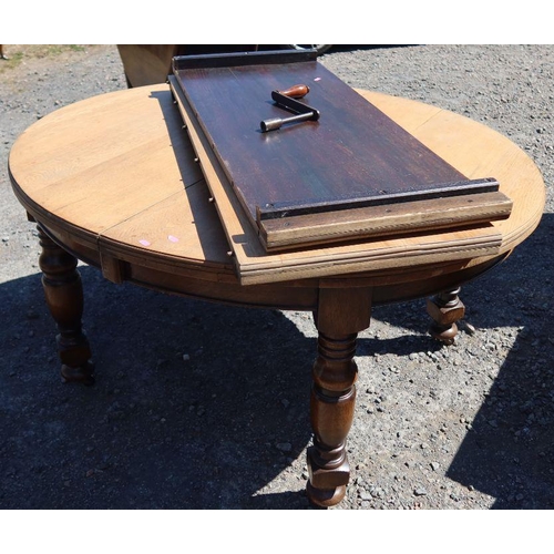 24 - An oak extending dining table, raised on turned legs, with two leaves and winder, closed 55ins x 47.... 