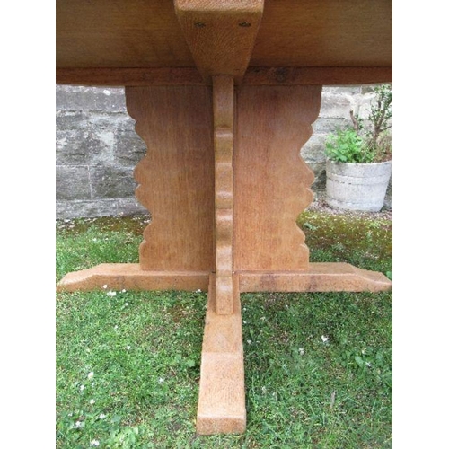 25 - An octagonal oak dining table, with concave borders, raised on cross frame legs, with outswept suppo... 