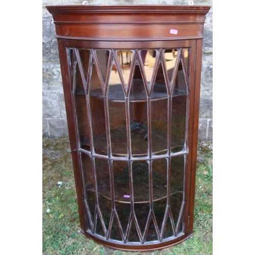 50 - A mahogany barrel front corner cupboard, with fancy glazed door, opening to reveal three shelves, he... 