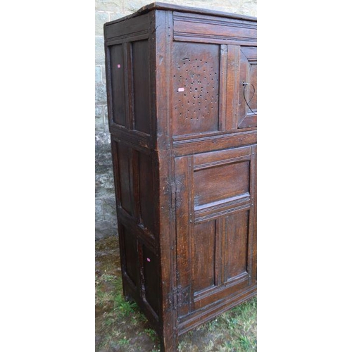 51 - An antique oak duadarn, the upper panelled section fitted with a cupboard, the base with a pair of c... 