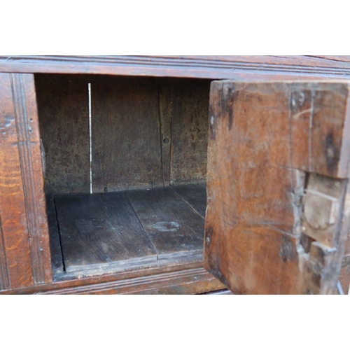 51 - An antique oak duadarn, the upper panelled section fitted with a cupboard, the base with a pair of c... 