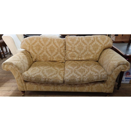 61 - A pair of three seater sofas, in gold patterned upholstery, with fire labels