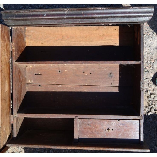 1 - An antique oak wall cupboard, the panelled door opening to reveal shelves and a small drawer, 25ins ... 