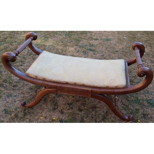 112 - A Regency design mahogany window seat, with scroll ends and upholstered seat, raised on a cross base... 