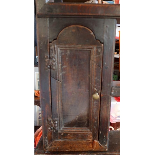 21 - An antique oak dresser, the base fitted with three short drawers over cupboards, with open rack over... 