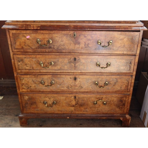 23 - An antique walnut cabinet on chest, the upper section fitted with a pair of mirrored doors, opening ... 