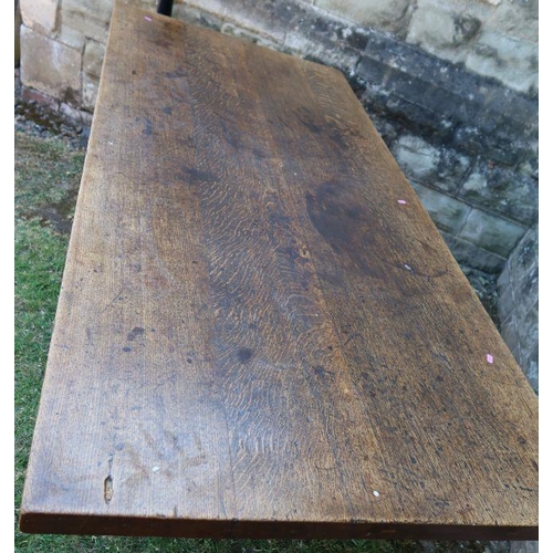 24 - An antique oak refectory dining table, fitted with a frieze drawer, raised on end supports united by... 