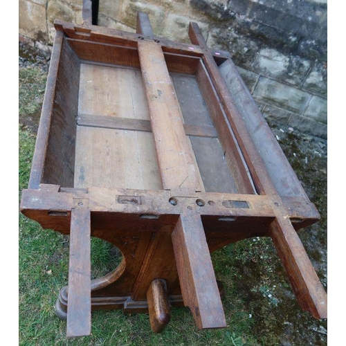 24 - An antique oak refectory dining table, fitted with a frieze drawer, raised on end supports united by... 