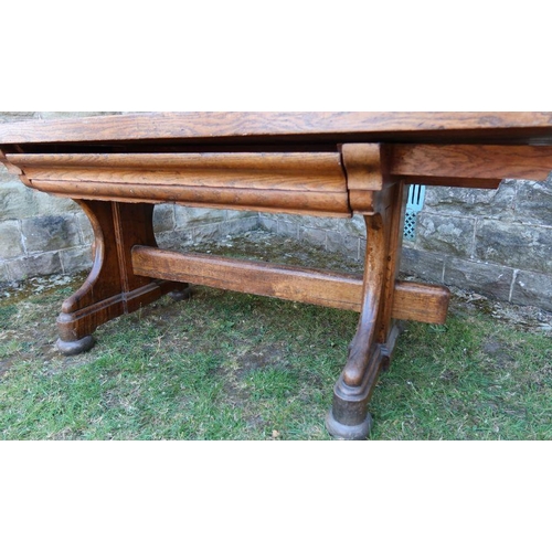 24 - An antique oak refectory dining table, fitted with a frieze drawer, raised on end supports united by... 