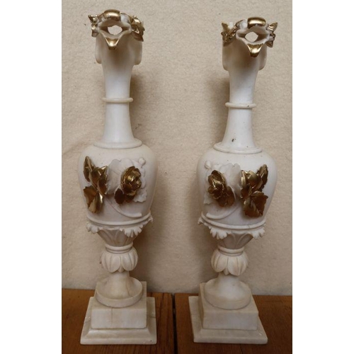 242 - A pair of alabaster urns, the spouts carved with stylised birds heads, with leaf decoration and gild... 