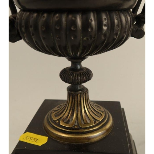 245 - A pair of 19th century mantel urns, in black and gold, on stepped square bases, height 12.5ins