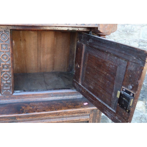 26 - An antique oak court cupboard, fitted with two cupboards to the upper section, and a central cupboar... 