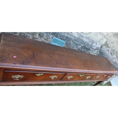 75 - An oak dresser base, fitted with three frieze drawers, raised on scroll legs terminating in pad feet... 