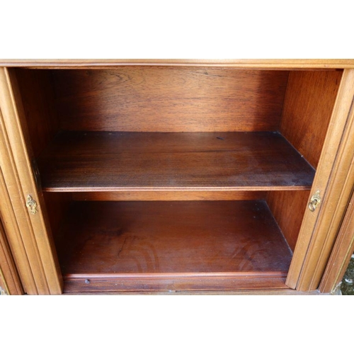 79 - A mahogany cabinet, fitted with shelves behind a pair of curtains, over a tambour front cupboard wit... 